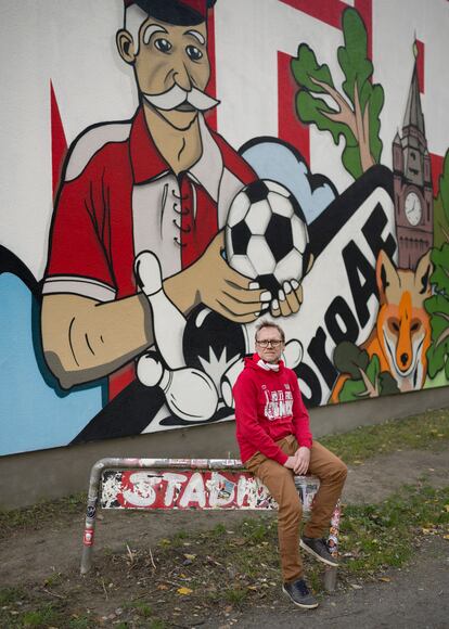 Silvio Titzmann, fan del equipo, retratado junto a uno de los murales cercanos al estadio. D