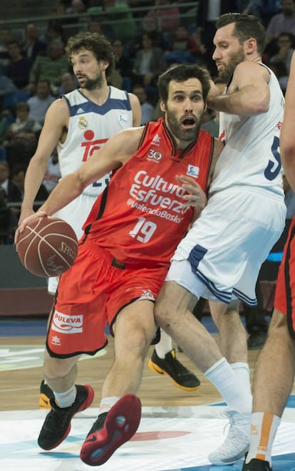 El alero del Valencia Basket, Fernando San Emeterio (i), conduce el balón ante el jugador del Real Madrid, Rudy Fernández.