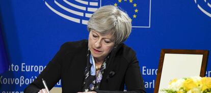 Theresa May firma en el libro de condolencias del Parlamento Europeo por el funeral de Helmut Khol. 