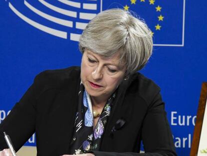 Theresa May firma en el libro de condolencias del Parlamento Europeo por el funeral de Helmut Khol. 