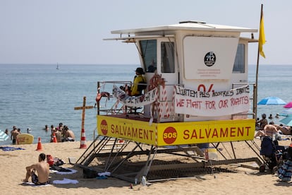 Una torre de vigilancia en la playa de la Barceloneta con varios carteles en referencia a la huelga de socorristas en Barcelona, este lunes.