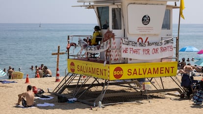 Una torre de vigilancia en la playa de la Barceloneta con varios carteles en referencia a la huelga de socorristas en Barcelona, este lunes.