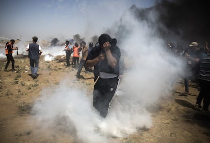 Un palestino se protege del gas lacrimógeno lanzado por las fuerzas israelíes contra el pueblo palestino en la Franja de Gaza.