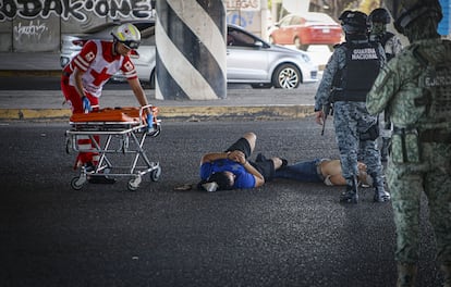 Autoridades auxilian a personas heridas de bala en Culiacán, el 19 de mayo.
