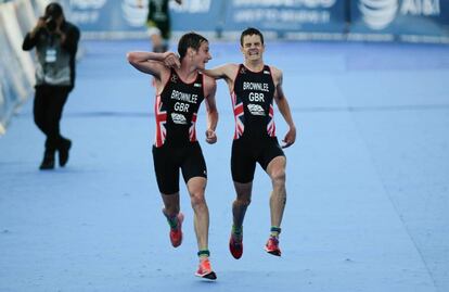 Alistair Brownlee (izquierda) ayuda a su hermano Jonathan Brownlee a terminar la carrera despu&eacute;s de que este desfalleciera. 