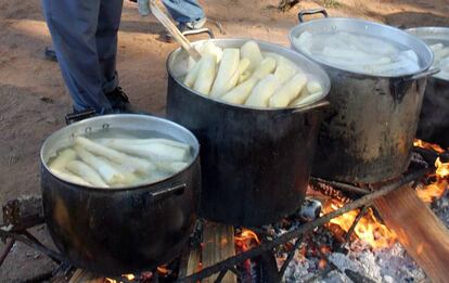 Un campesino paraguayo prepara ollas de yuca.