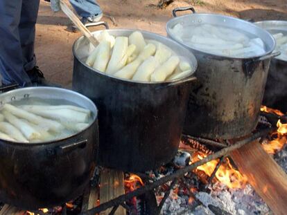 Un campesino paraguayo prepara ollas de yuca.