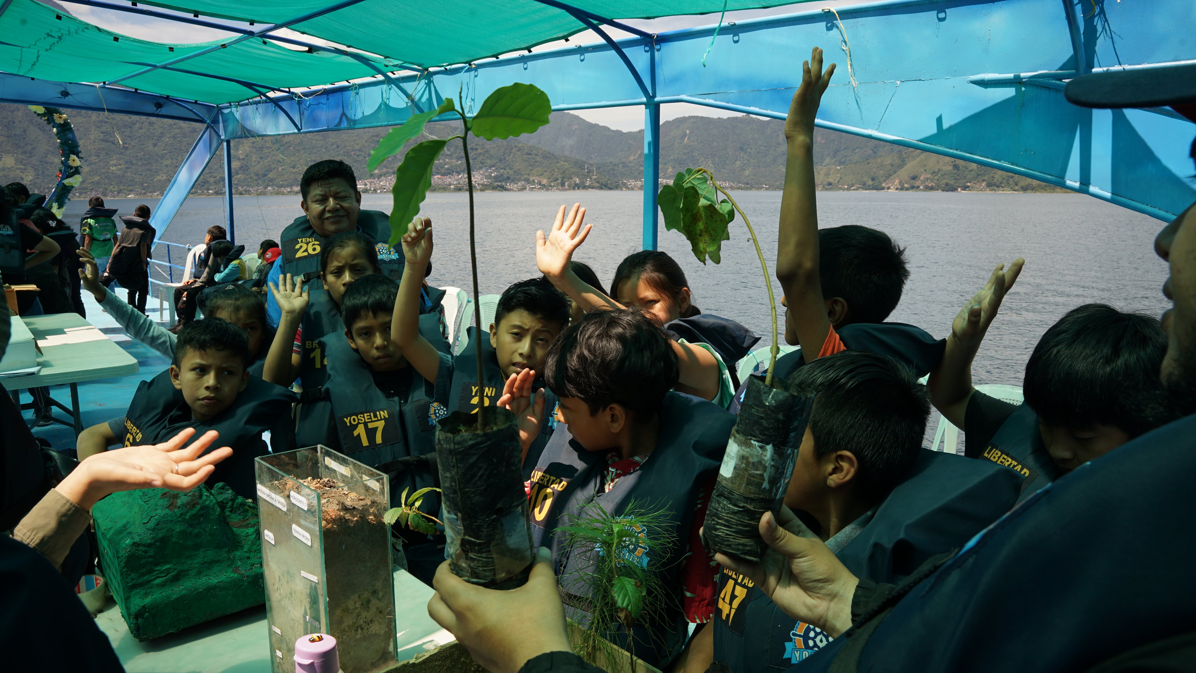 Clases con chalecos salvavidas en una escuela flotante para salvar el Lago de Atitlán