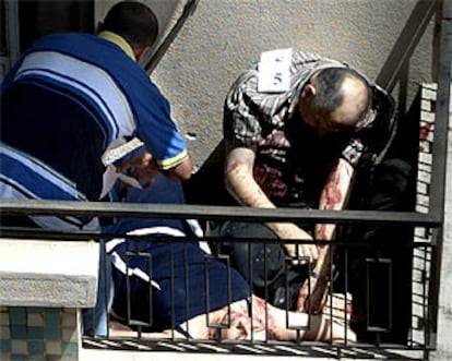 Un policía libanés examina los cadáveres de dos víctimas del tiroteo de ayer en Beirut.