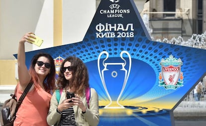 Dos mujeres se fotografían ante un logo de la final de Kiev.