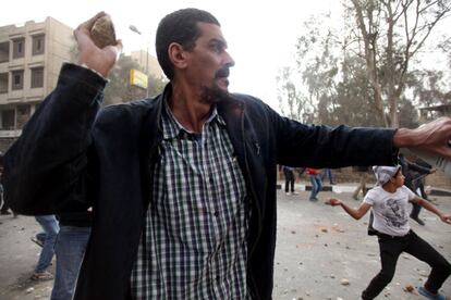 Egipcios lanzan piedras durante los enfrentamientos entre opositores y partidarios. Los choques entre los bandos se extendieron a zonas ubicadas a 800 metros a la redonda del edificio de los Hermanos Musulmanes, mientras los antidisturbios emplearon gases lacrimógenos para evitar que los opositores alcanzaran la sede.