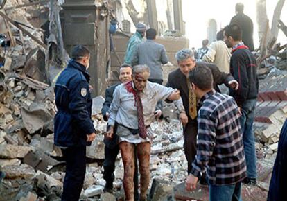 Un hombre herido recibe ayuda entre los escombros de la entrada del Consulado británico tras la explosión.