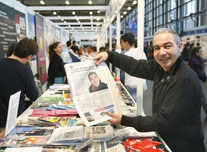 El escritor catalán Andreu Carranza, encargado de inaugurar la feria, muestra su imagen impresa en un periódico local