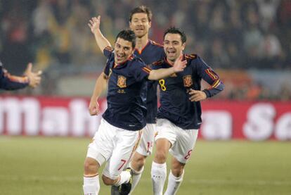 Villa celebra su gol, el primero de España, con Xabi Alonso y Xavi.