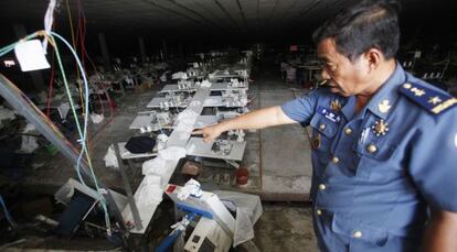Un policía señala el punto donde se produjo el derrumbe de una de las plantas de una empresa textil de Camboya.