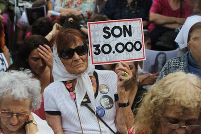 Una mujer sostiene un cartel que hace referencia a los 30.000 desaparecidos mientras escucha la lectura del veredicto por los crímenes cometidos en la Escuela de Mecánica de la Armada (ESMA).