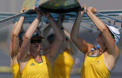 El equipo australiano femenino de remo transporta su bote después del entrenamiento.