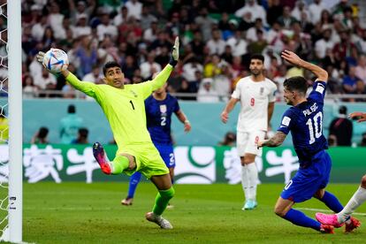 El portero iraní, Alireza Beiranvand, trata infructuosamente de atajar el balón lanzado por el estadounidense Christian Pulisic en la jugada que supuso el primer gol de EEUU.