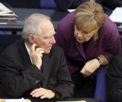 La canciller alemana, Angela Merkel, habla con el ministro de Finanzas, Wolfgang Sch&auml;uble durante el debate general sobre los presupuestos nacionales para 2013 en el Bundestag, Parlamento alem&aacute;n, en Berl&iacute;n, Alemania, el martes 20 de noviembre de 2012. 