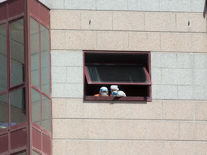 Trabajadores de la residencia de mayores DomusVi intervenida en Outeiro de Rei (Lugo) se asoman a una ventana.