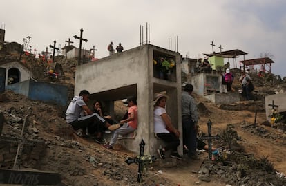 Uma família visita a tumba de um ser querido no cemitério de Vila María de triunfo (Peru), o 1 de novembro de 2016.