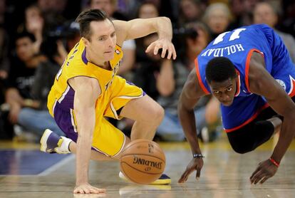 Steve Nash trata de recuperar un balón ante Jrue Holiday.