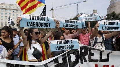 Unos manifestantes en la plaza de Cataluña de Barcelona convocan a acudir al Aeropuerto de El Prat (Barcelona) para protestar por la sentencia del 'procés', este lunes.