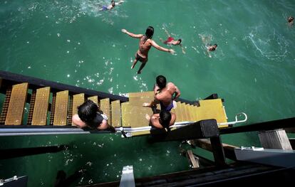 Un adolescente salta desde el muelle de Henley Beach en Adelaide (Australia). Las temperaturas se dispararon en el sur de Australia, subiendo a cerca de 50 grados centígrados en algunas ciudades regionales.
