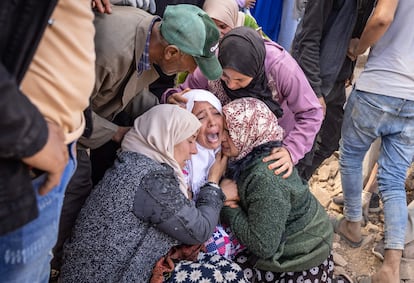 Varias mujeres lloran mientras los voluntarios recuperan el cuerpo de un miembro de la familia entre los escombros en Imi N'Talade, el 10 de septiembre. 