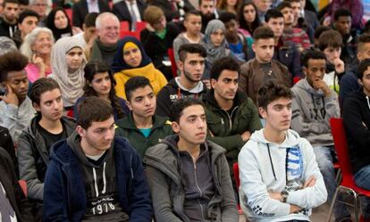 Migrantes asisten ayer en Ansbach a una charla del ministro de Justicia.