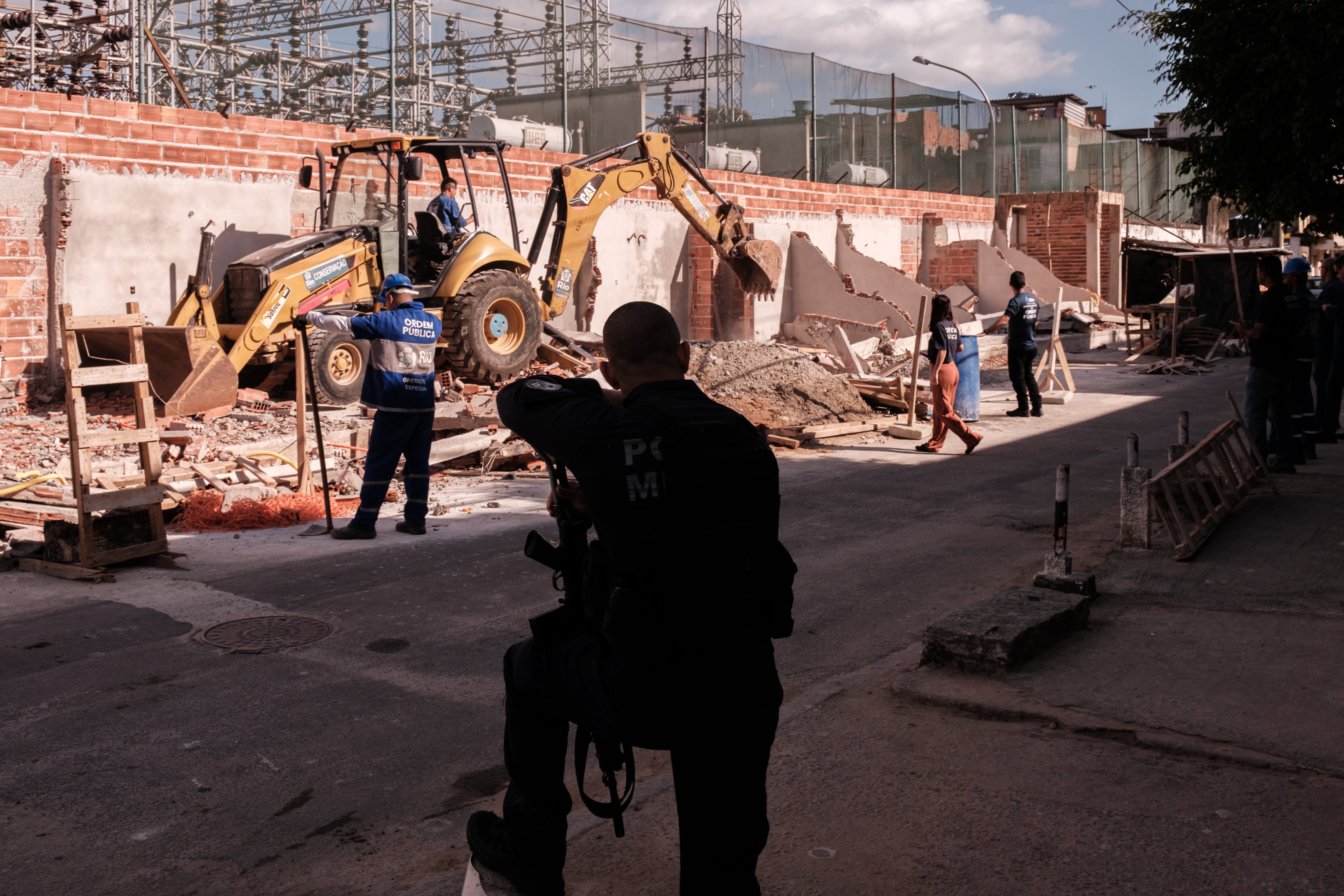 La Policía militar escolta a los trabajadores durante las demoliciones.