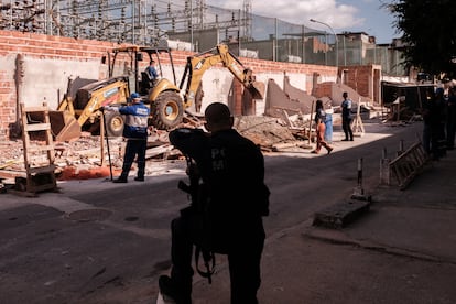 La Policía militar escolta a los trabajadores durante las demoliciones.
