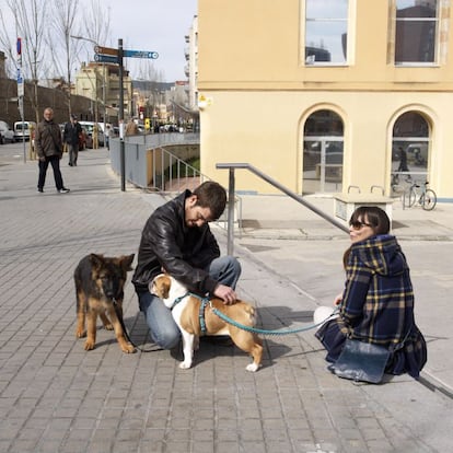 Dos jóvenes frente al local de la Biblioteca Ignasi Iglesias-Can Fabra, en el barrio de Sant Andreu, en Barcelona.