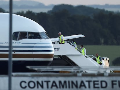 Miembros de la tripulación subían el martes al avión fletado para transportar a los inmigrantes desde el Reino Unido a Ruanda, en la localidad de Wiltshire.