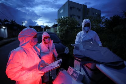 Agentes se preparam para examinar o corpo de Lacy Braga de Oliveira, que morreu aos 84 em casa, em Manaus.