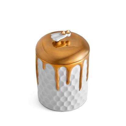 Evoca un panal de abejas, pero es una vela de parafina perfumada de la marca de decoración de lujo L’Objet. El objeto contrasta con la geometría atemporal de la colmena. En la parte superior, unas brillantes gotas de oro de 24 quilates sugieren una apetecible y rebosante miel. De hecho, la colección se completa con un tarro para miel con un diseño similar. La contenedor de la vela, confeccionado cuidadosamente en porcelana, se remata con unas simpáticas alas, que funcionan como tirador y refuerzan la idea del mundo natural. Precio: 195 euros.