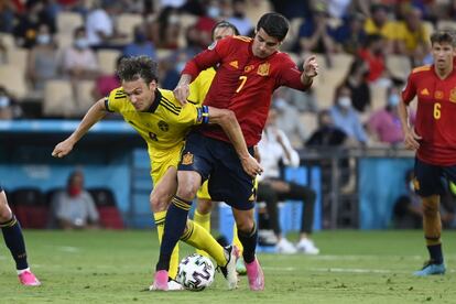 El jugador sueco Albin Ekdal lucha por hacerse con la posesión del balón ante el delantero de España Álvaro Morata.