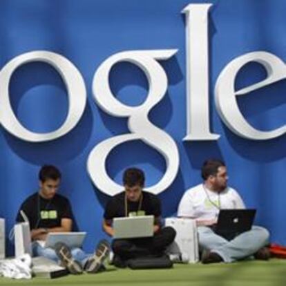 Jóvenes utilizan sus ordenadores debajo del logo de Google en Madrid.