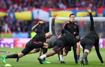 Mesut Ozil del Arsenal calienta con sus compañeros antes del partido. 