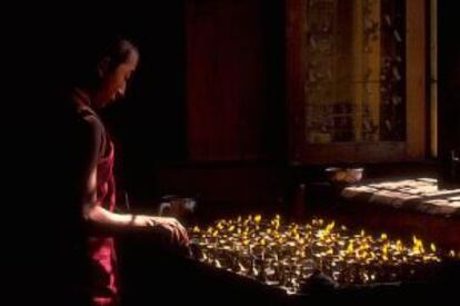 Un monje budista enciende velas en un templo de Bodnath, en Katmandú (Nepal).