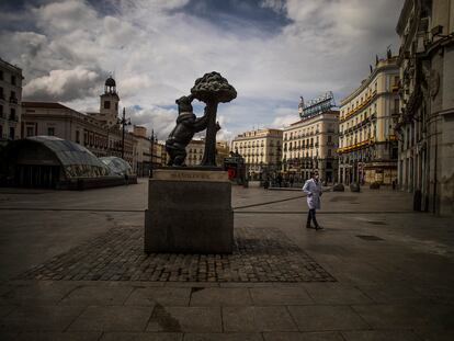 Un hombre con mascarilla camina por la Puerta del Sol de Madrid, vacía durante las semanas de confinamiento por la covid-19 en marzo de 2020.