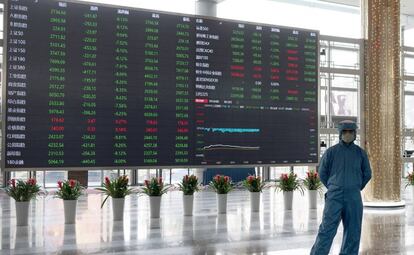 Trabajadores con traje de protección, en el interior de la Bolsa de Shanghai.