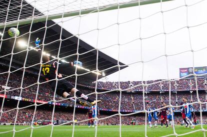La pilota disparada per Leo Messi, que no apareix a la foto, entra per l'esquadra i aconsegueix el primer gol per al seu equip.