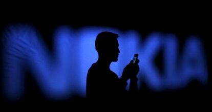 Un usuario de móvil junto a un logo de Nokia en la ciudad bosnia de Zenica