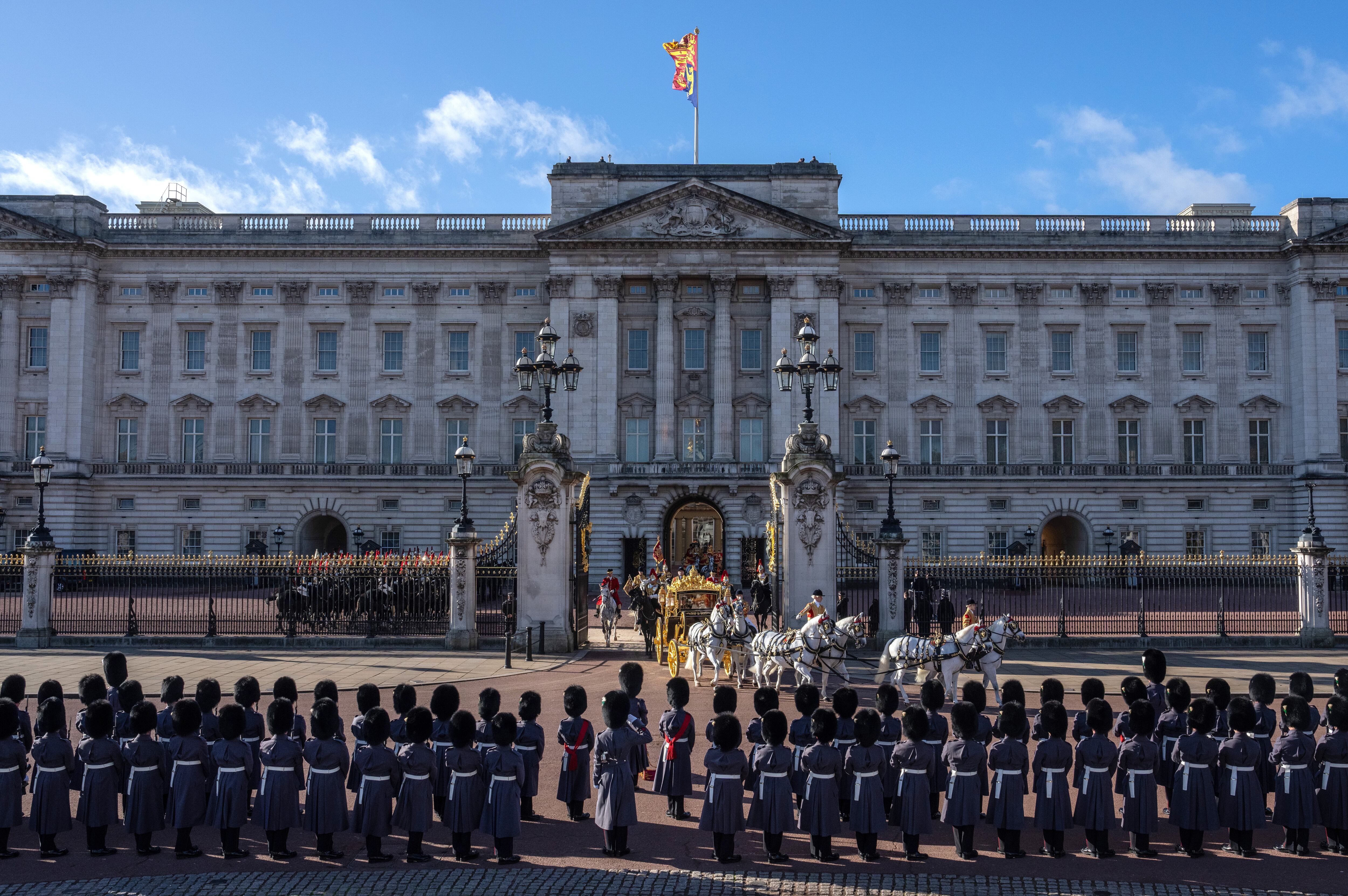 Miembros de la Guardia del Rey se alinean fuera del Palacio de Buckingham mientras el rey Carlos III y la reina Camila salen hacia las Casas del Parlamento antes del discurso del monarca, este martes en Londres. 