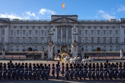 Miembros de la Guardia del Rey se alinean fuera del Palacio de Buckingham mientras el rey Carlos III y la reina Camila salen hacia las Casas del Parlamento antes del discurso del monarca, este martes en Londres. 