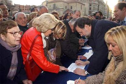 Mariano Rajoy firma en contra del nuevo Estatuto catalán durante un acto político en León.