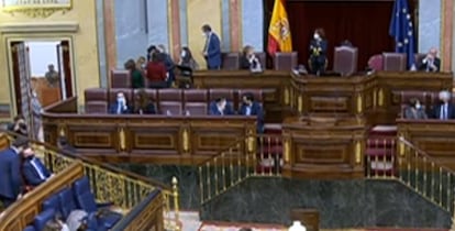 La imagen, de mala calidad al proceder de un fotograma de vídeo, muestra a la izquierda, arriba, la reunión informal en la tribuna del hemiciclo antes de la votación, pero con el proceso ya iniciado.