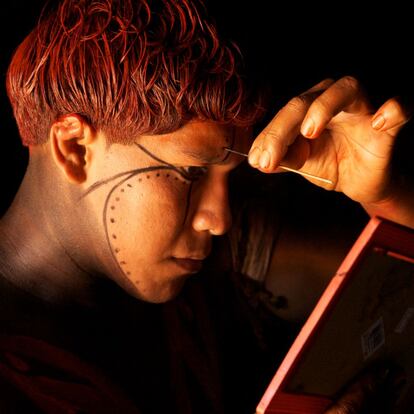 Un hombre del pueblo indígena yawalapiti decora su rostro con pintura en la intimidad de su hogar. Yawalapiti, Brasil, 2011