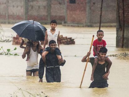 Varios nepalíes huyen de sus casas inundadas en Ramgadhwa, en Nepal, este domingo.